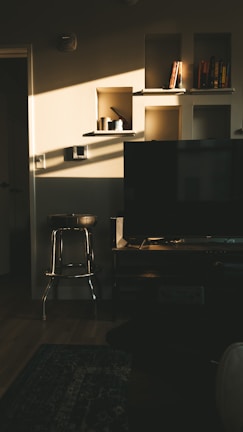 A cozy residential living room featuring custom built-in shelves and soft lighting.