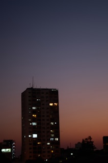 High-rise apartment building lit up at dusk.