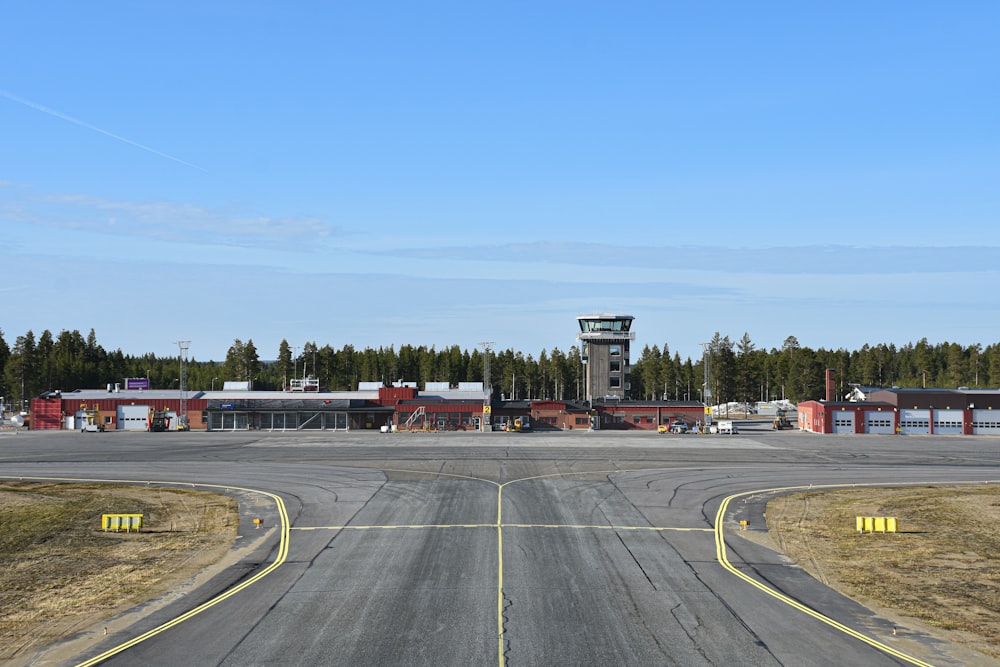 an airport runway with a control tower in the background