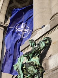 a statue of a man holding a flag in front of a building