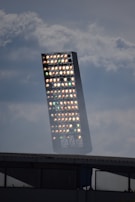 Wide angle view of a solar lighting tower casting bright white light over construction machinery.