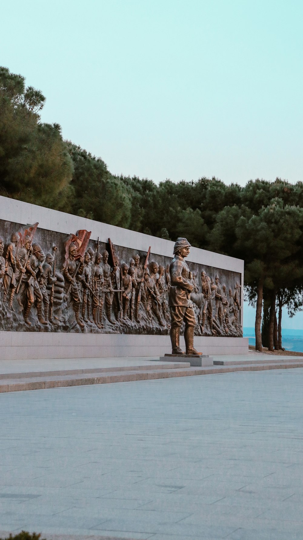 a statue of a soldier standing in front of a wall