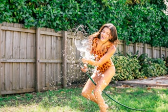 a woman in a leopard print bathing suit spraying water on her body