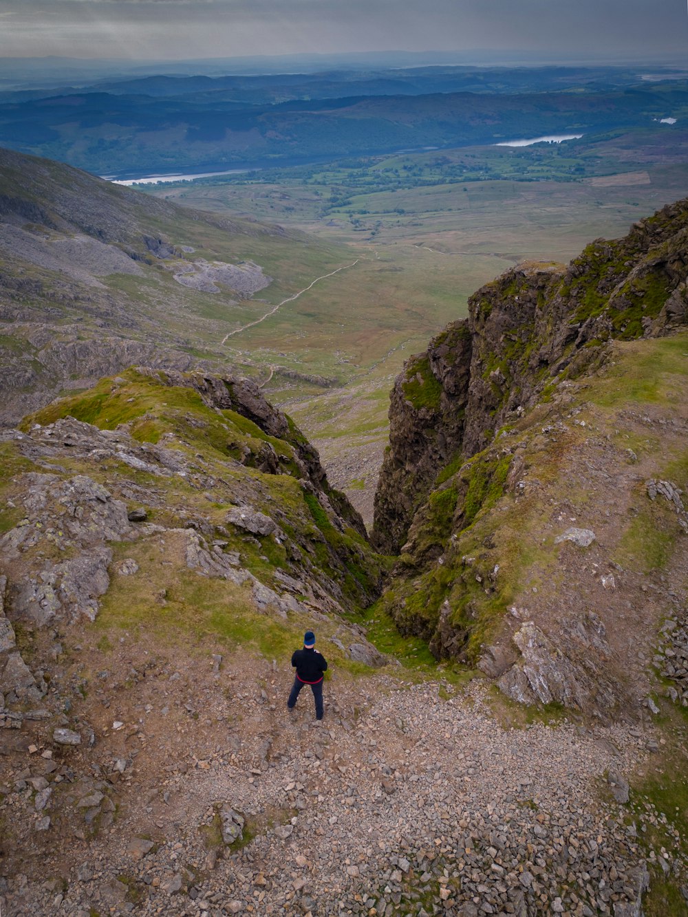 a man standing on top of a lush green hillside