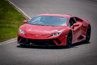 A sporty car fitted with shiny, precision-engineered wheels driving on a coastal road.
