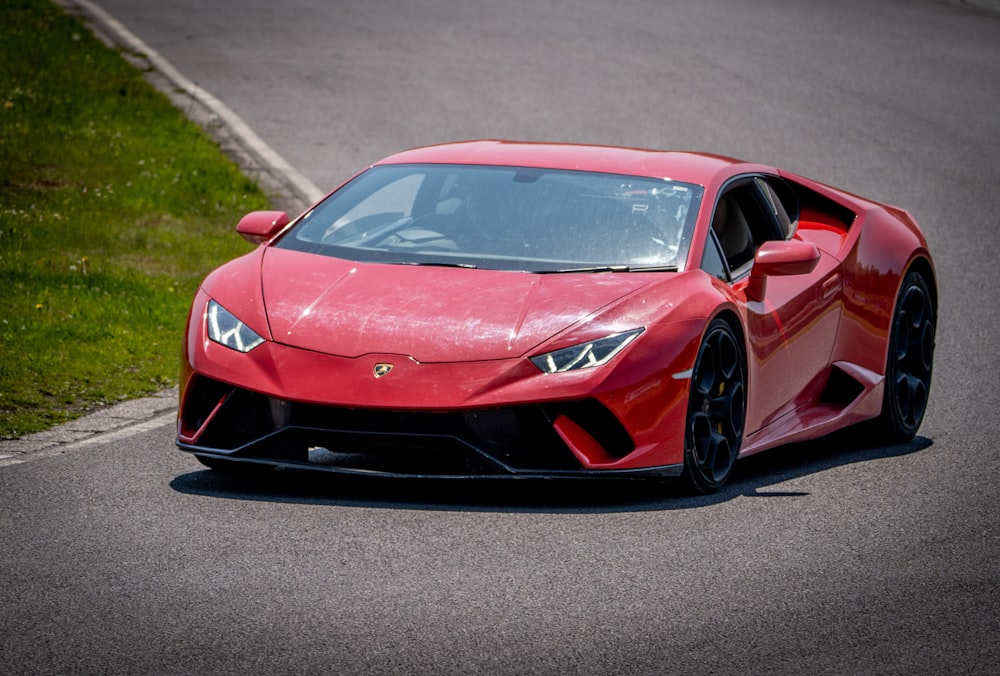 a red sports car driving down a race track