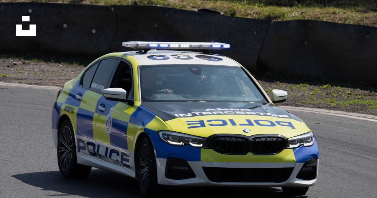 A police car driving down a race track photo – Free Three sisters race ...
