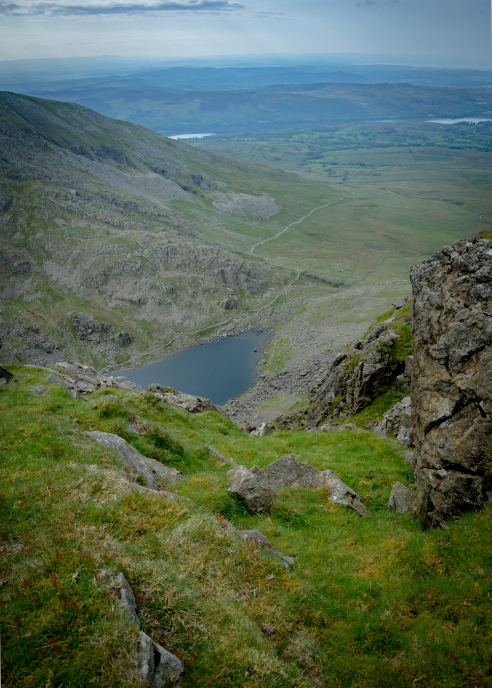 a view of a valley with a lake in the middle of it