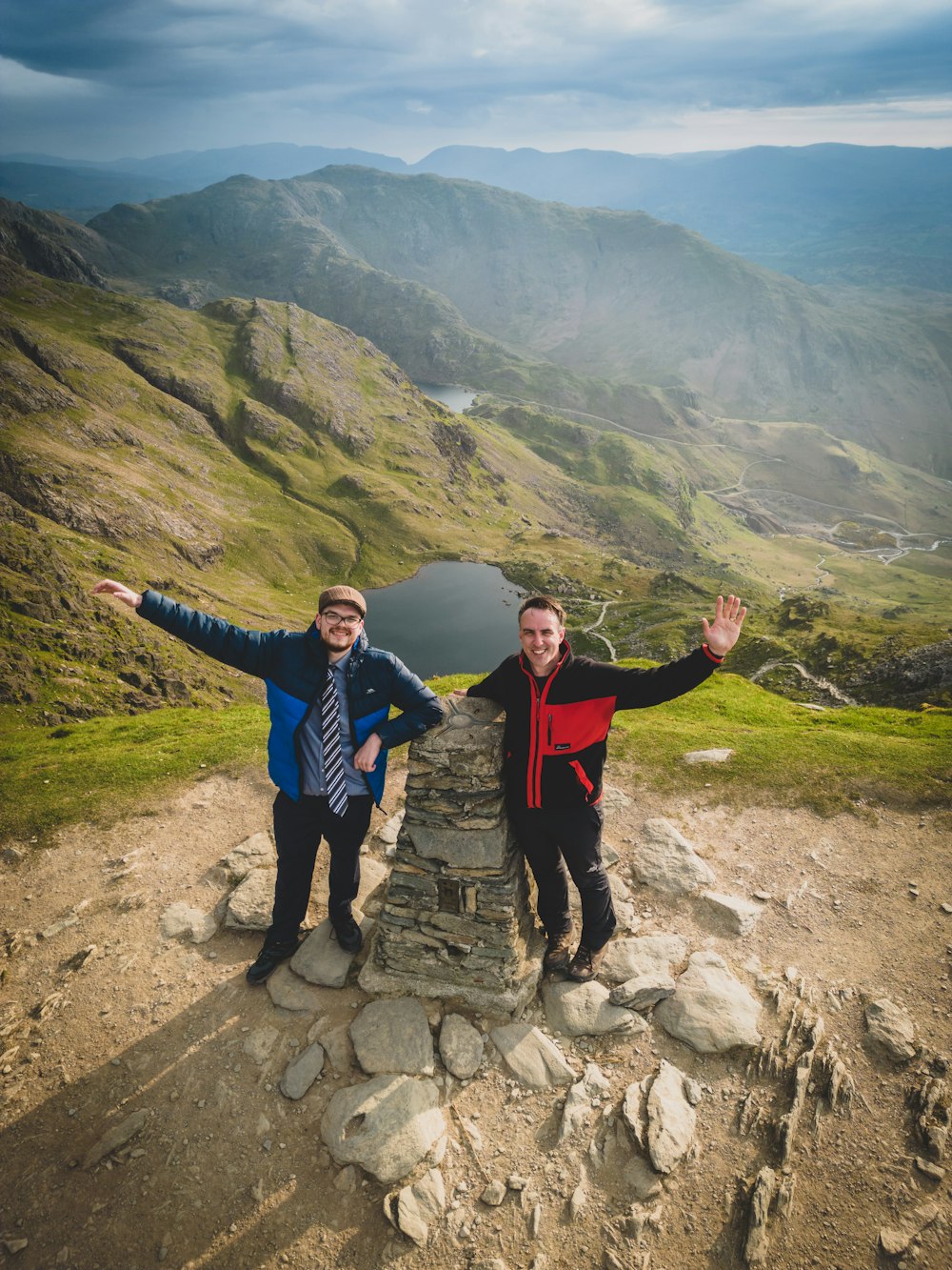 a couple of men standing on top of a mountain