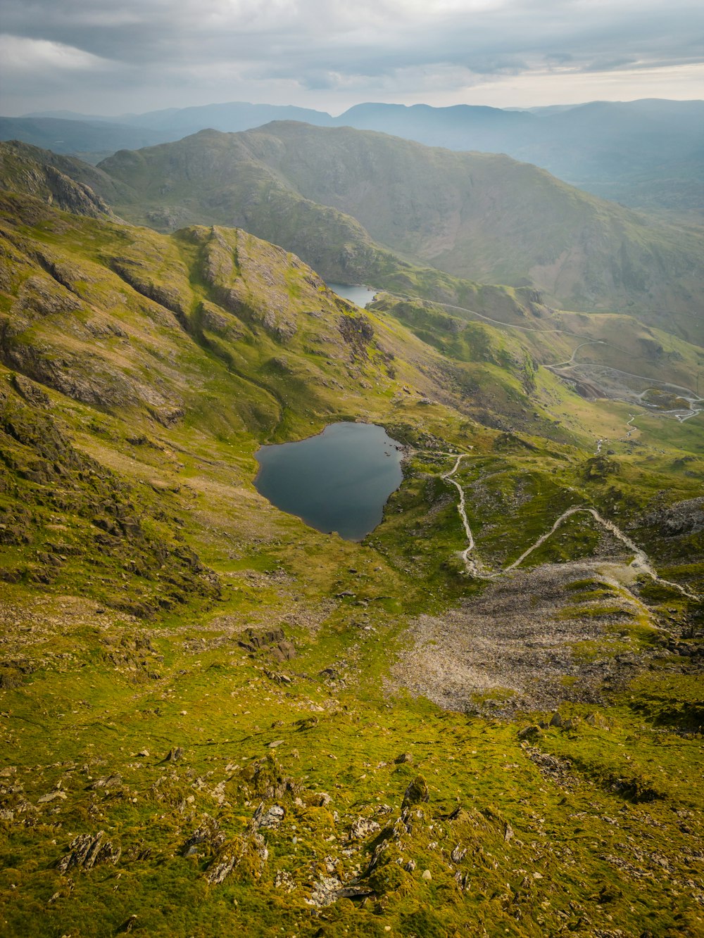 a small lake in the middle of a green valley