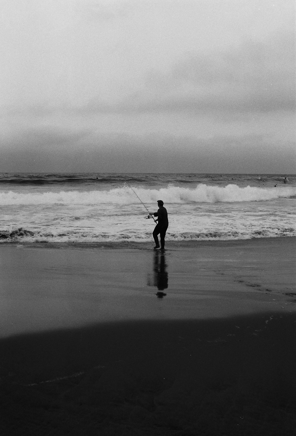 a man standing on top of a beach next to the ocean