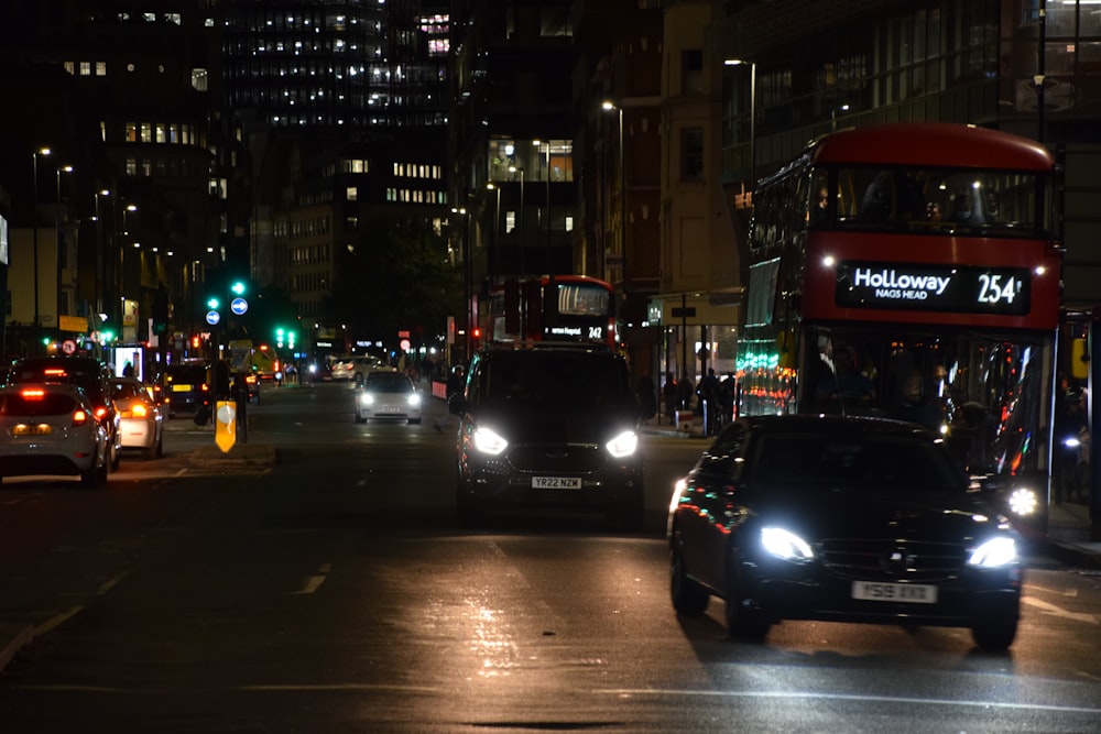 a double decker bus driving down a city street at night