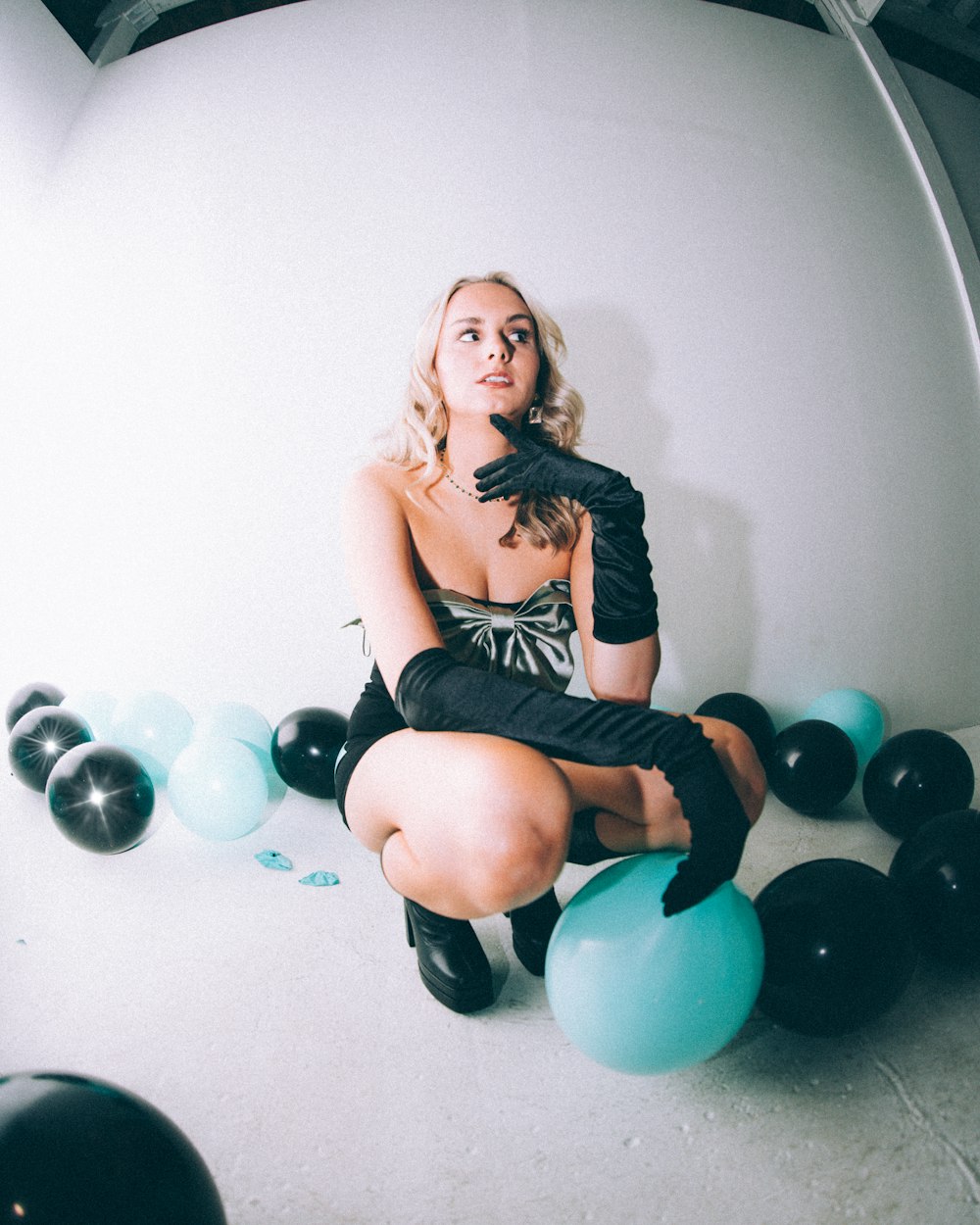 a woman sitting on top of balloons in a room