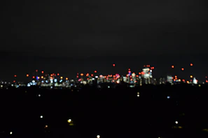 A blurred background of a city skyline at night with colorful lights