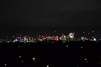 A blurred background of a city skyline at night with colorful lights