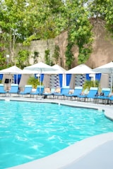 a large swimming pool with chairs and umbrellas
