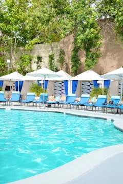 a large swimming pool with chairs and umbrellas