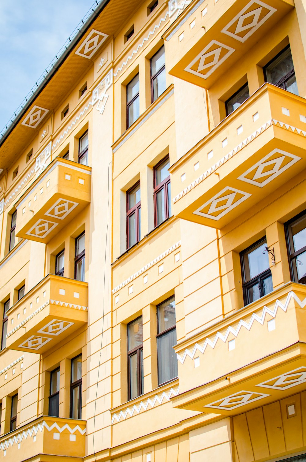 a yellow building with many windows and balconies