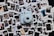 A collection of various instant photographs spread out on a surface with a light blue instant camera placed in the center. The photographs capture different scenes and people, featuring portraits, outdoor settings, and candid moments. The arrangement is casual and slightly overlapping.