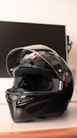 Close-up of a sleek motorcycle helmet with vibrant colors on a rustic wooden table.