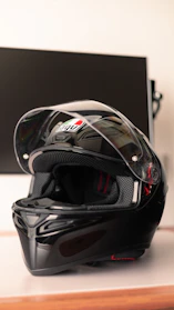 Close-up of a sleek motorcycle helmet resting on a rustic wooden table.