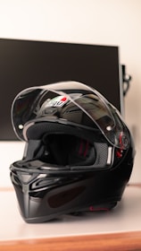 A close-up of a stylish motorcycle helmet and jacket displayed on a wooden table.