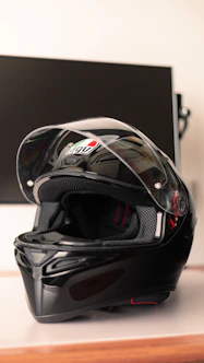 A sleek motorcycle helmet resting on a rugged metal surface under moody, industrial lighting.