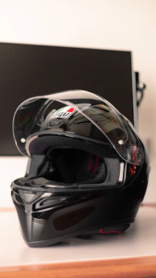 Close-up of a detailed black and silver motorcycle helmet on a wooden table