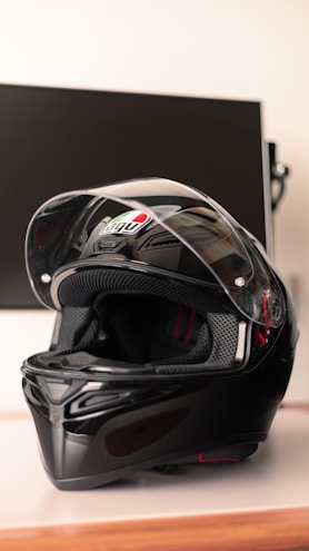 A sleek black and yellow motorcycle helmet on a minimalist gray background
