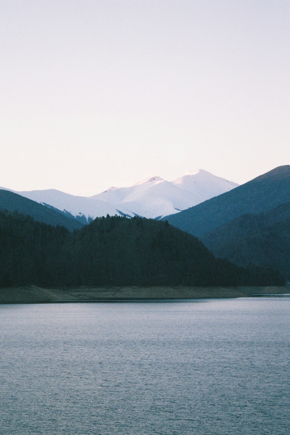 a large body of water with mountains in the background