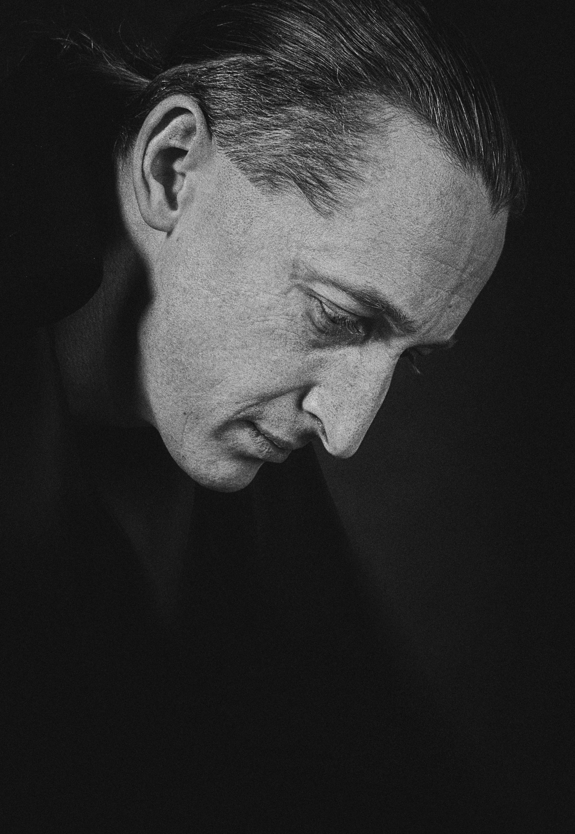 a black and white photo of a man looking down