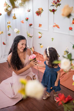 a woman kneeling down next to a little girl