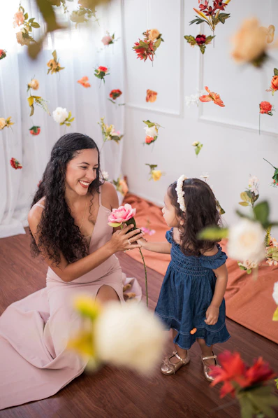 a woman kneeling down next to a little girl