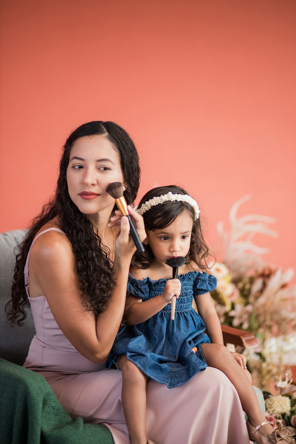 a woman sitting next to a little girl