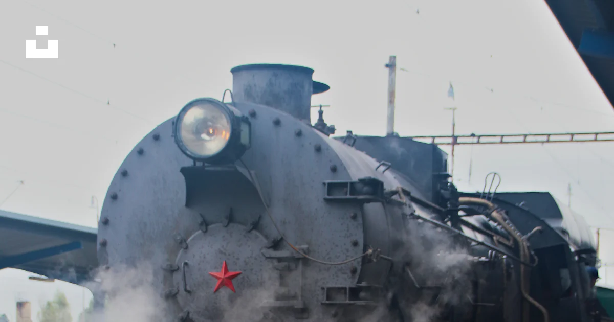A steam engine train pulling into a train station photo – Free ...