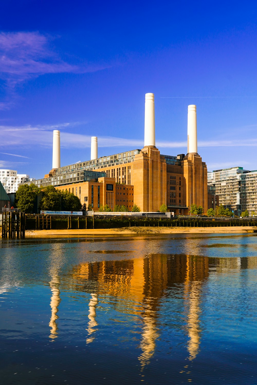 a body of water with a factory in the background