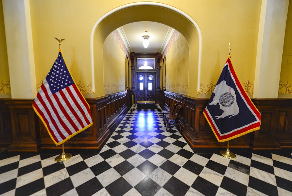 a hallway with a checkered floor and two flags