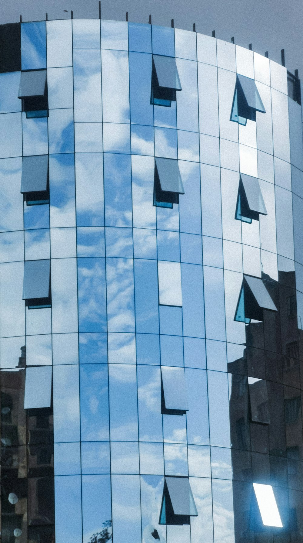 a building with a lot of windows reflecting the sky