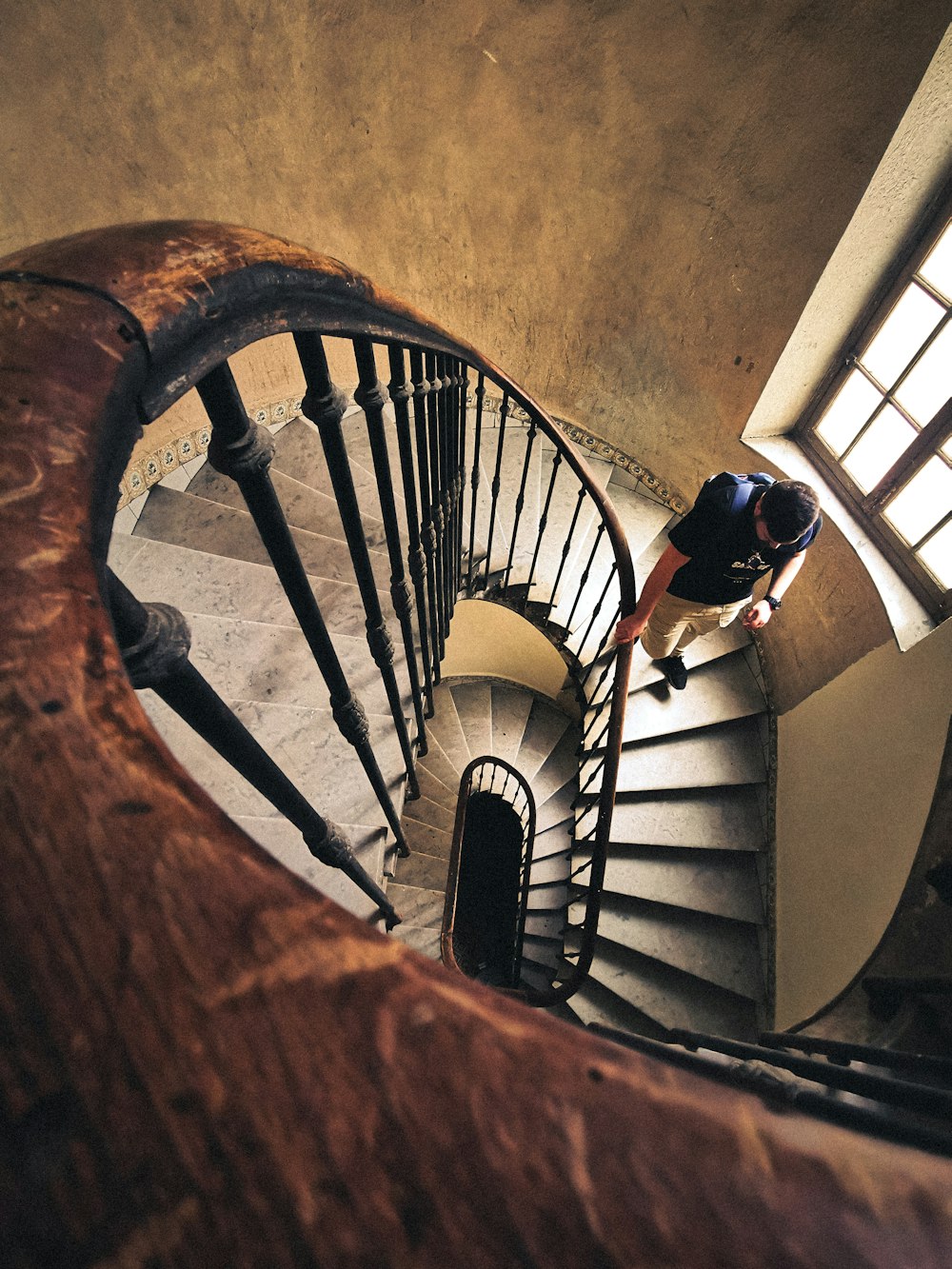 a man is climbing up a spiral staircase