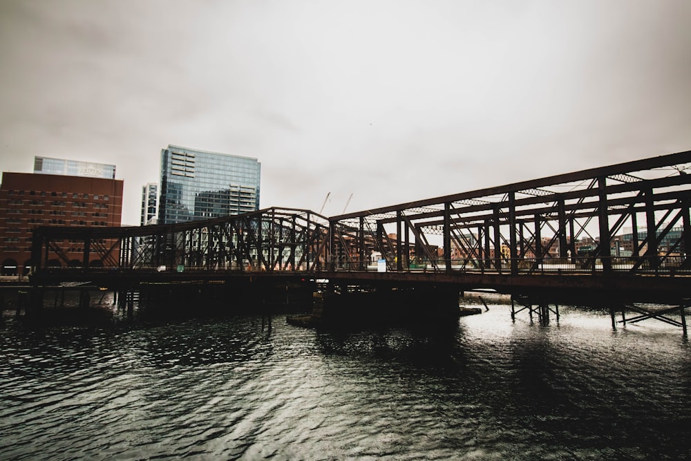 a bridge over a body of water with buildings in the background