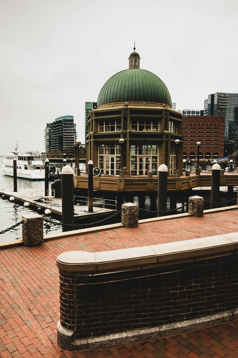 a bench on a brick walkway next to a body of water