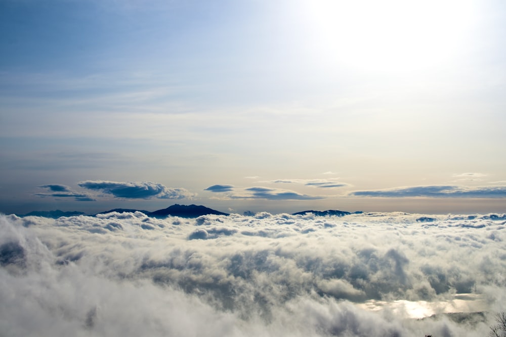 the sun is shining above the clouds in the sky