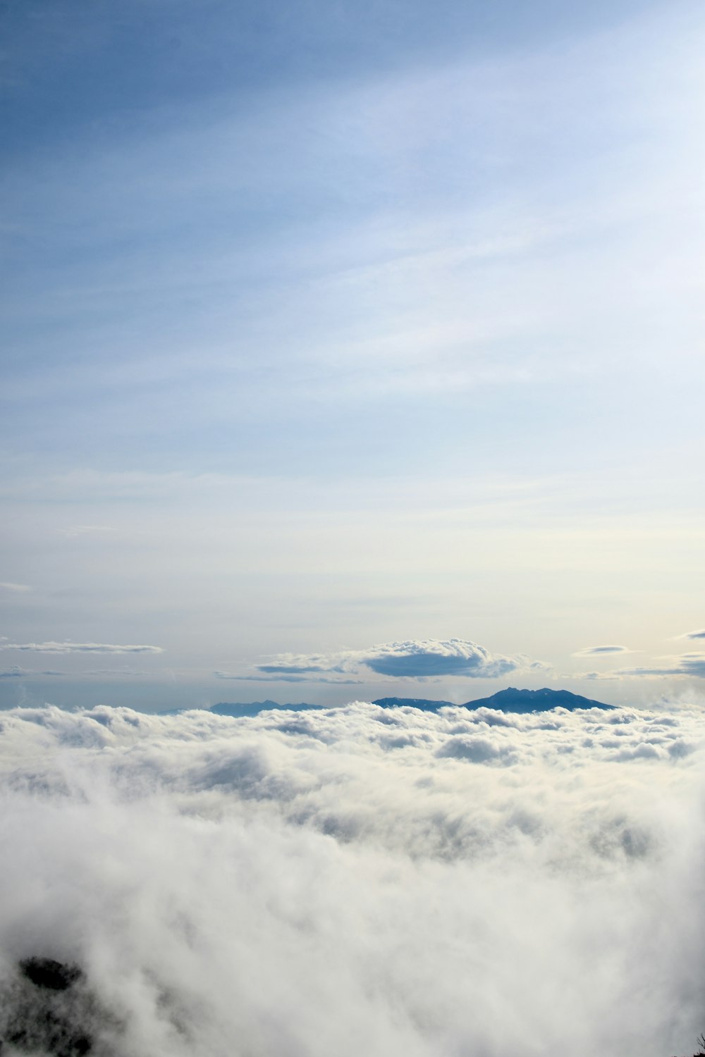 a person standing on top of a mountain above the clouds