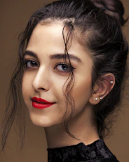a woman with dark hair and red lipstick