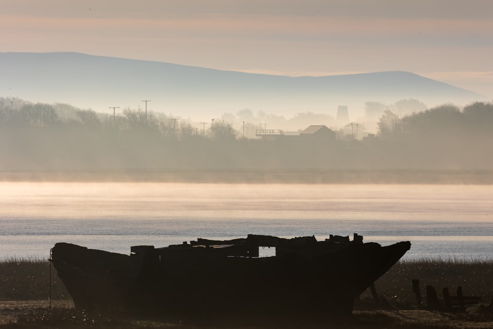 a boat sitting on top of a dry grass field