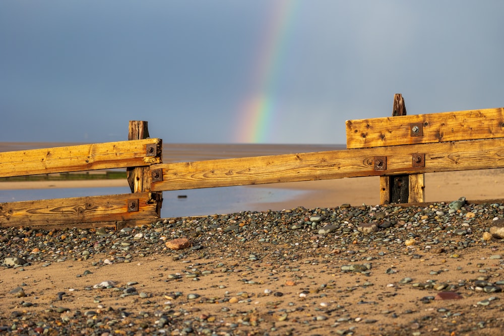 a wooden fence with a rainbow in the background