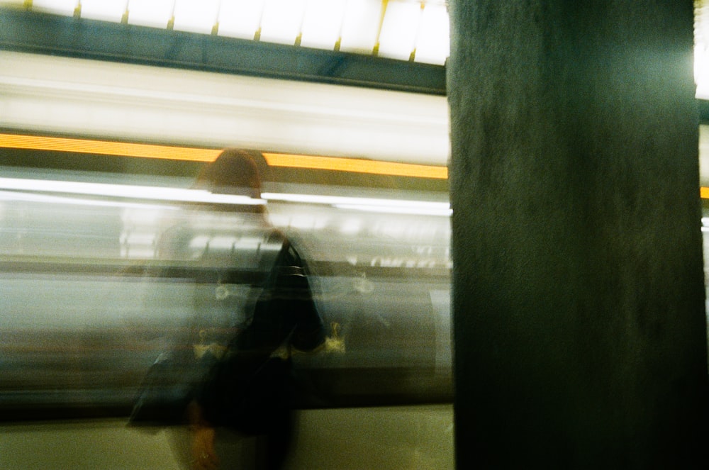 a blurry photo of a person walking on a subway platform