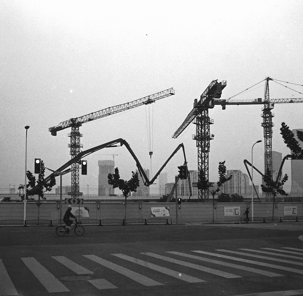 a black and white photo of construction cranes