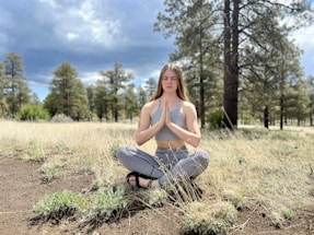 A serene landscape with a person praying outdoors.