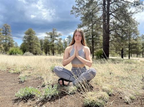 A serene landscape with a person praying outdoors.